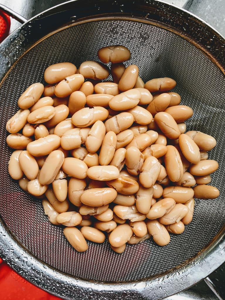 A can of cannelinni beans in a sieve